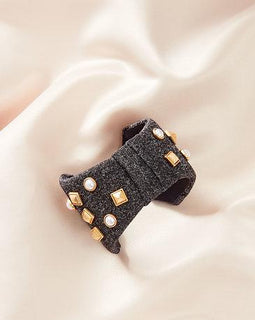 Bow Bracelet Pearls and stud details add dimension to this neoprene bow cuff Grey neoprene bow Stud and pearl details are hand sewn onto neoprene bow 2.25" Fits small to large wrist