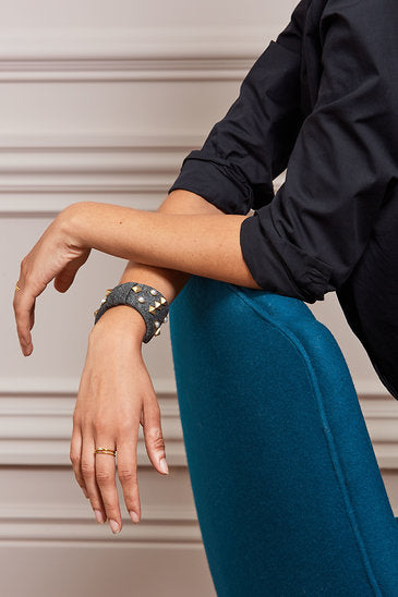 Bow Bracelet Pearls and stud details add dimension to this neoprene bow cuff Grey neoprene bow Stud and pearl details are hand sewn onto neoprene bow 2.25" Fits small to large wrist